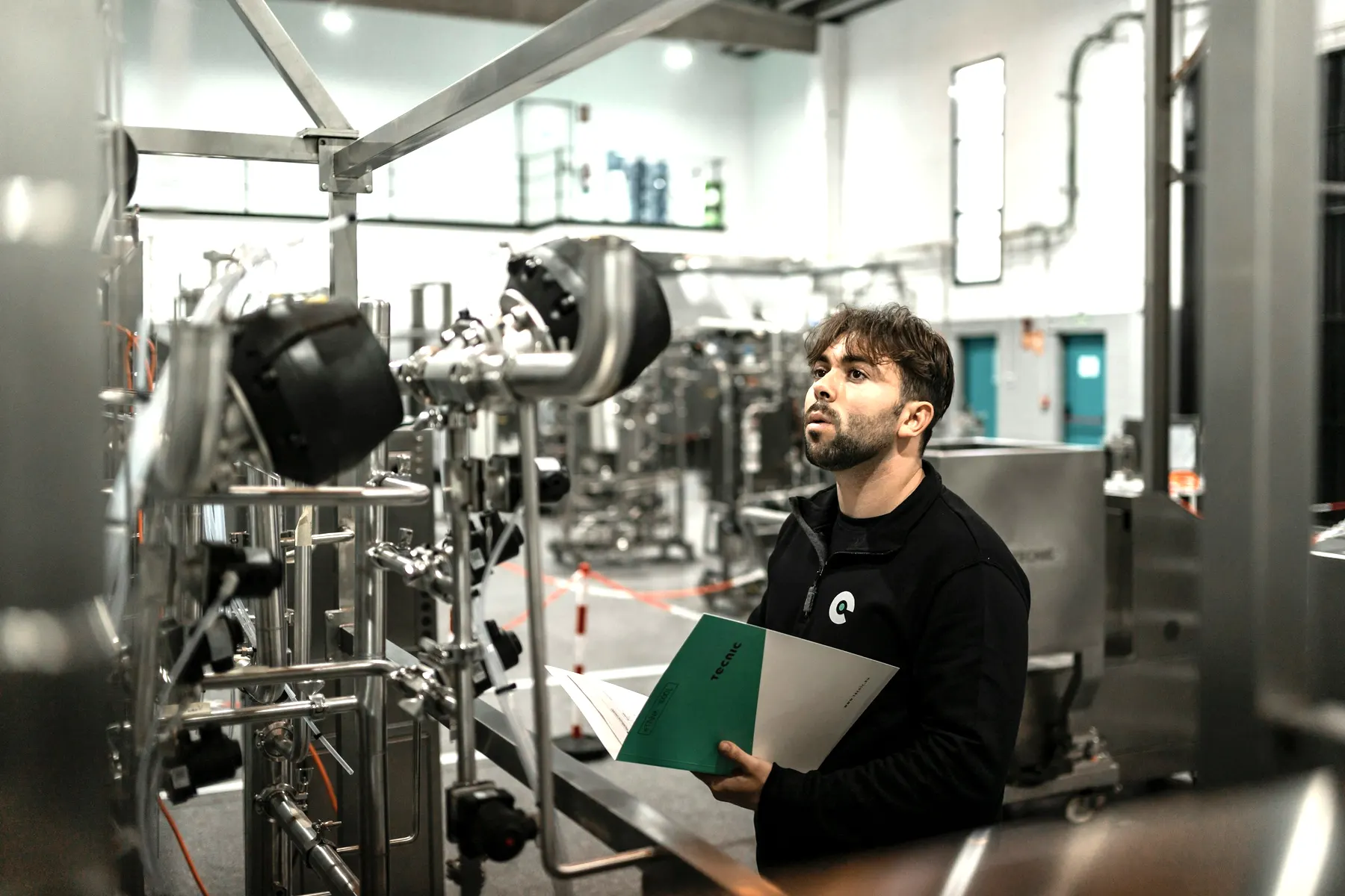 Auditor reviewing records against equipment on a production floor